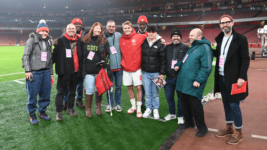 A photo containing some blind and partially sighted supporters pitchside at the Emirates Stadium with Martin Odegaard