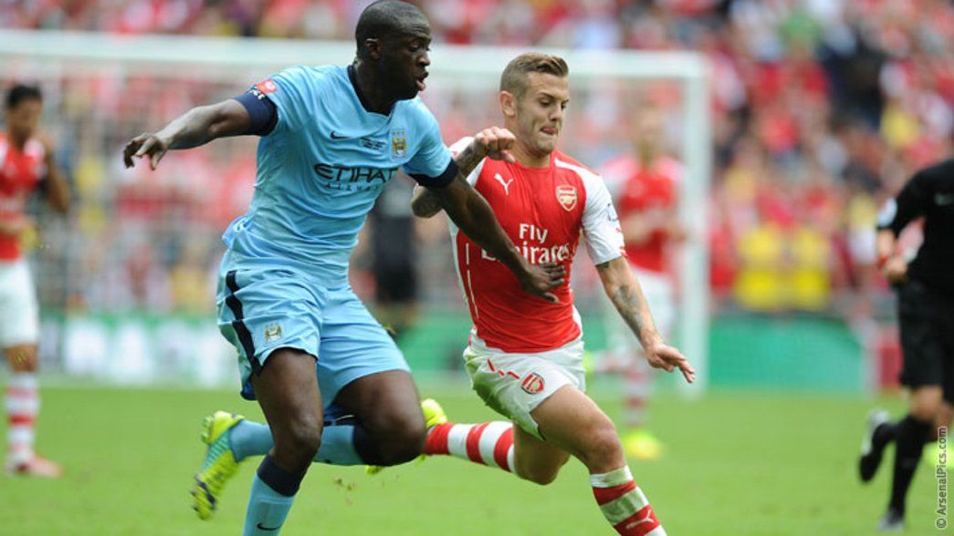 Jack Wilshere battles for possession with Yaya Toure at Wembley