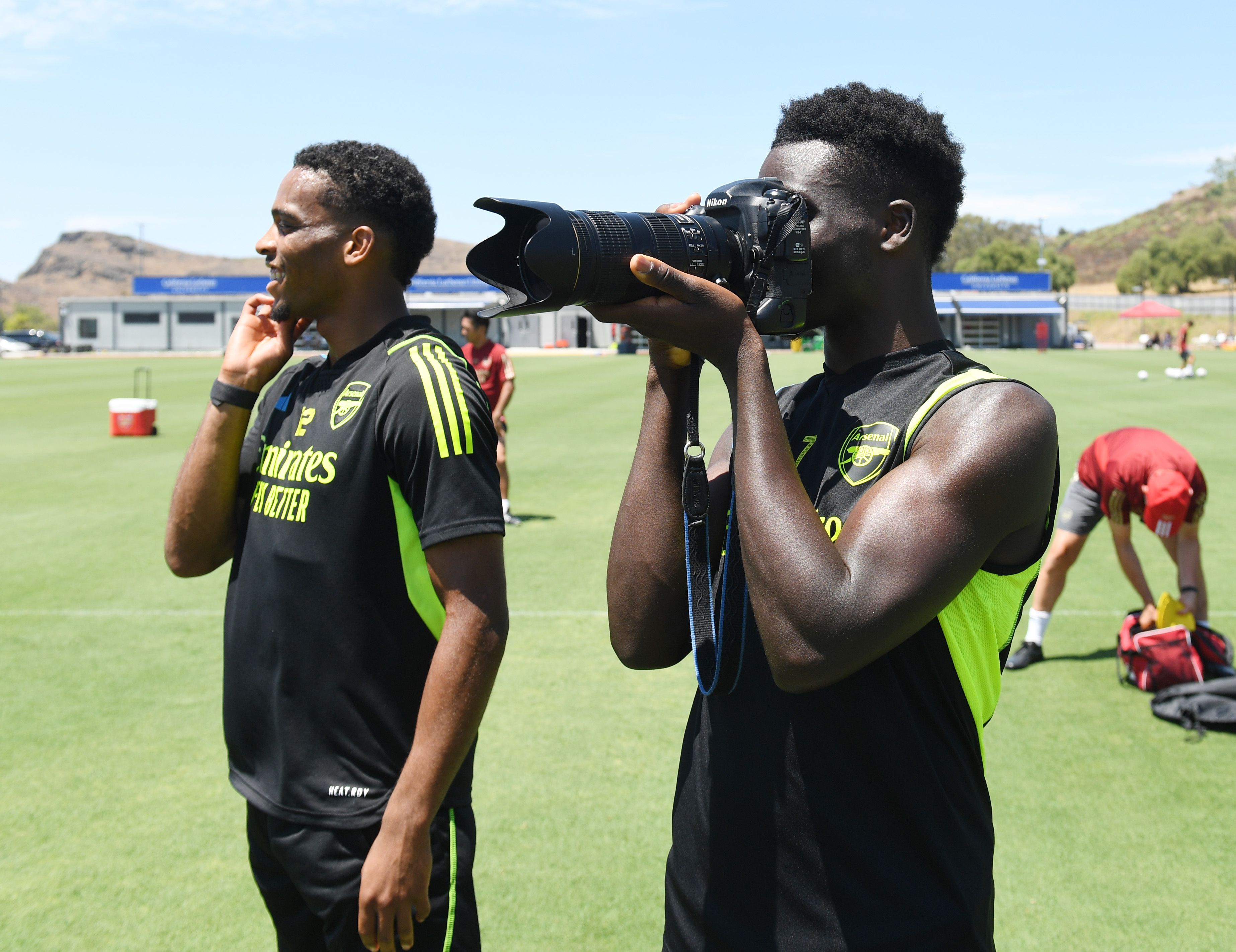 Bukayo Saka takes a photo standing next to Jurrien Timber