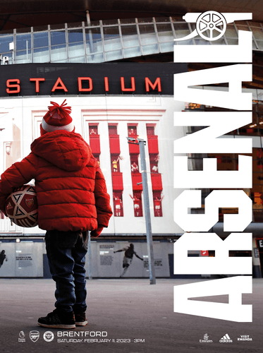 A child looks up at the 'Remember Who You Are' Emirates Stadium artwork, holding a football. Text reads: Arsenal v Brentford. Saturday, February 11, 2023