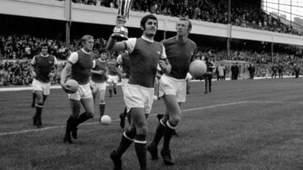 Frank McLintock shows off the trophy the following home game