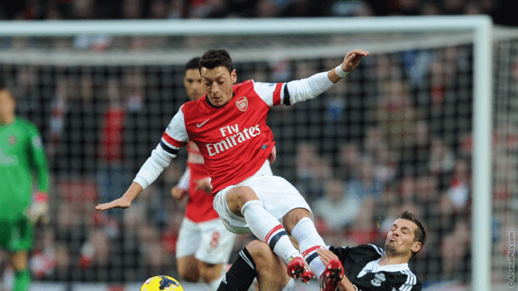 Mesut Ozil challenges for the ball