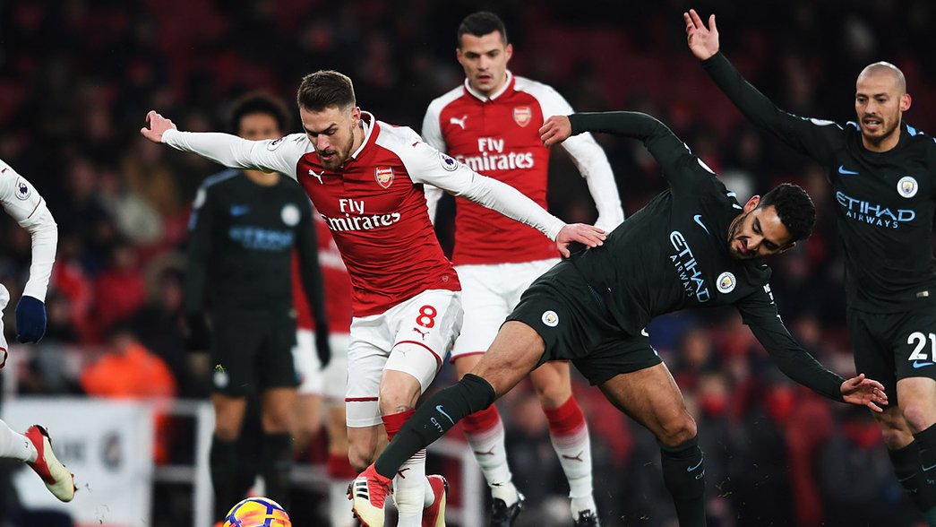 Aaron Ramsey battles for possession against Manchester City
