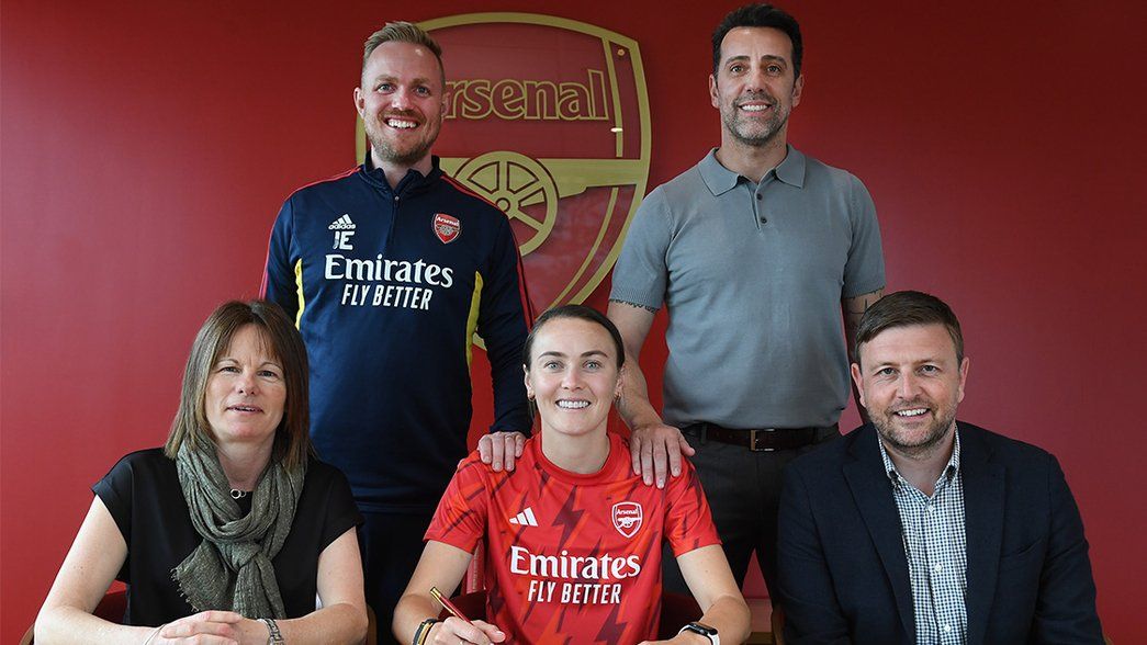 Caitlin Foord signs her new contract in the Arsenal boardroom, alongside Clare Wheatley, Jonas Eidevall, Edu Gaspar and Richard Garlick