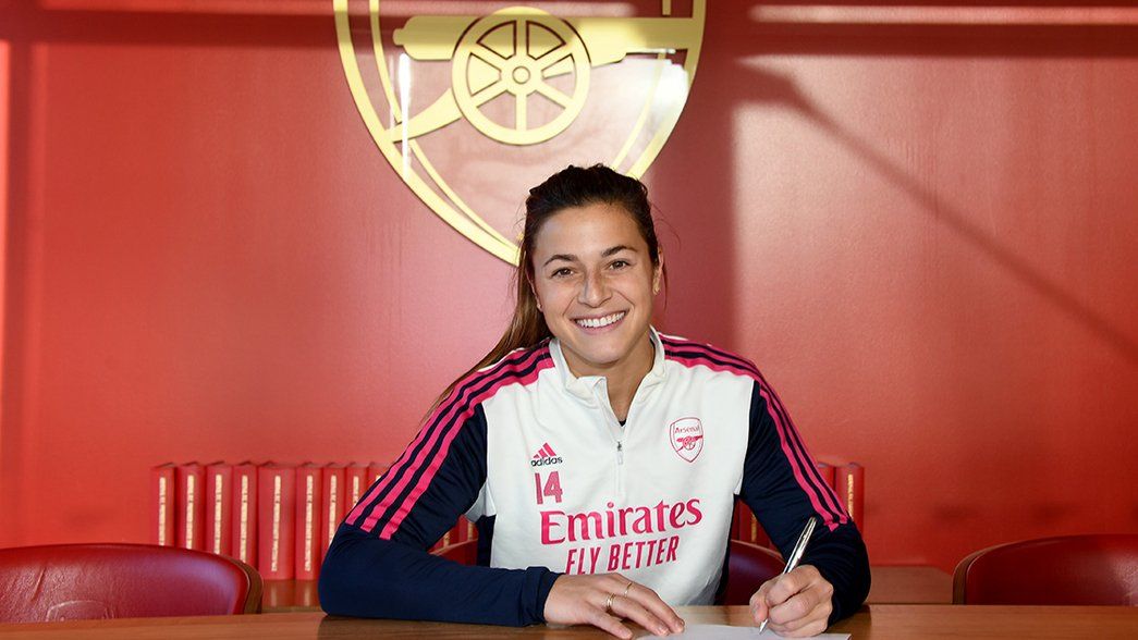 Sabrina D'Angelo signs her Arsenal contract in front of the Arsenal crest