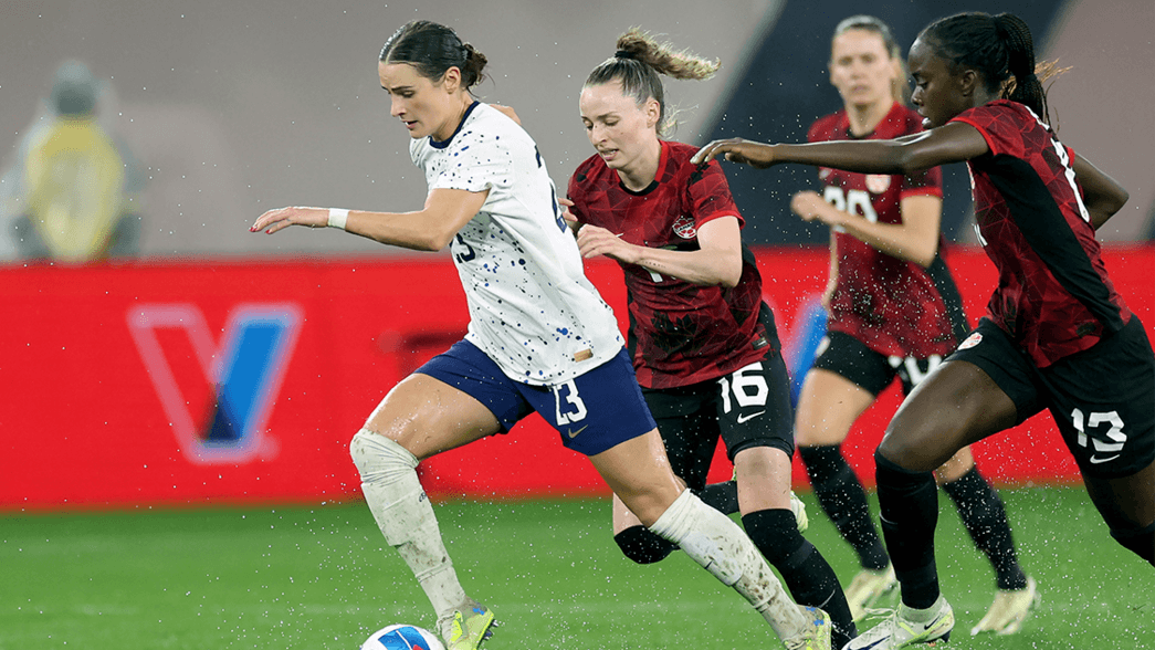 Emily Fox dribbles with three Canadian players in pursuit