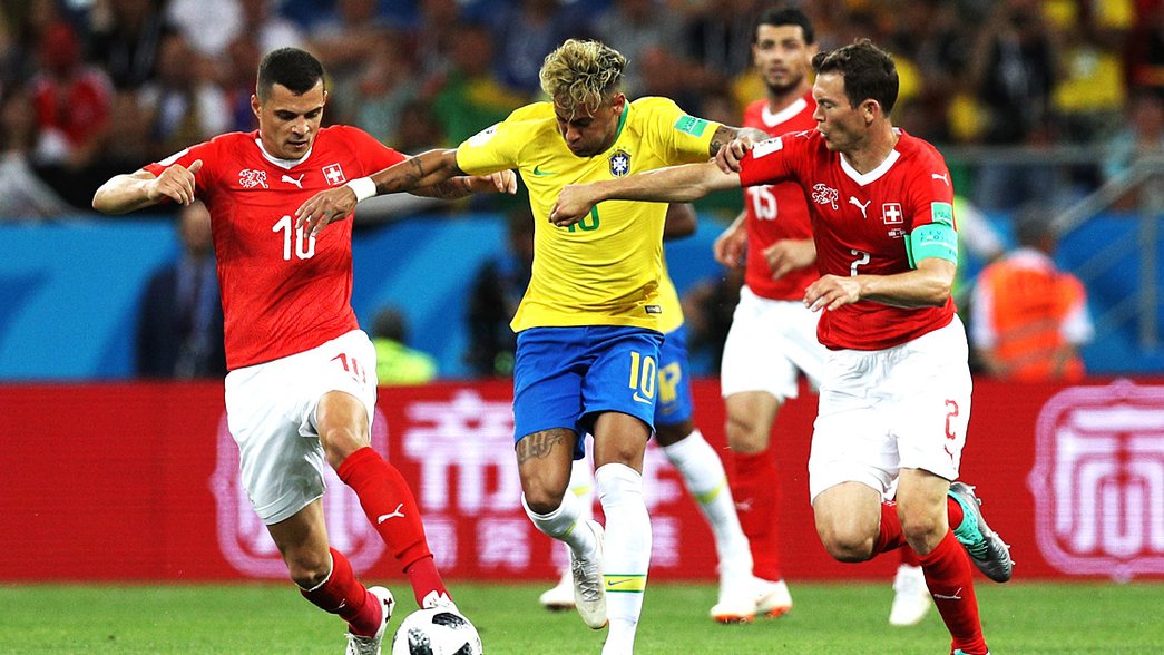 Granit Xhaka and Stephan Lichtsteiner battle for possession with Neymar at the World Cup