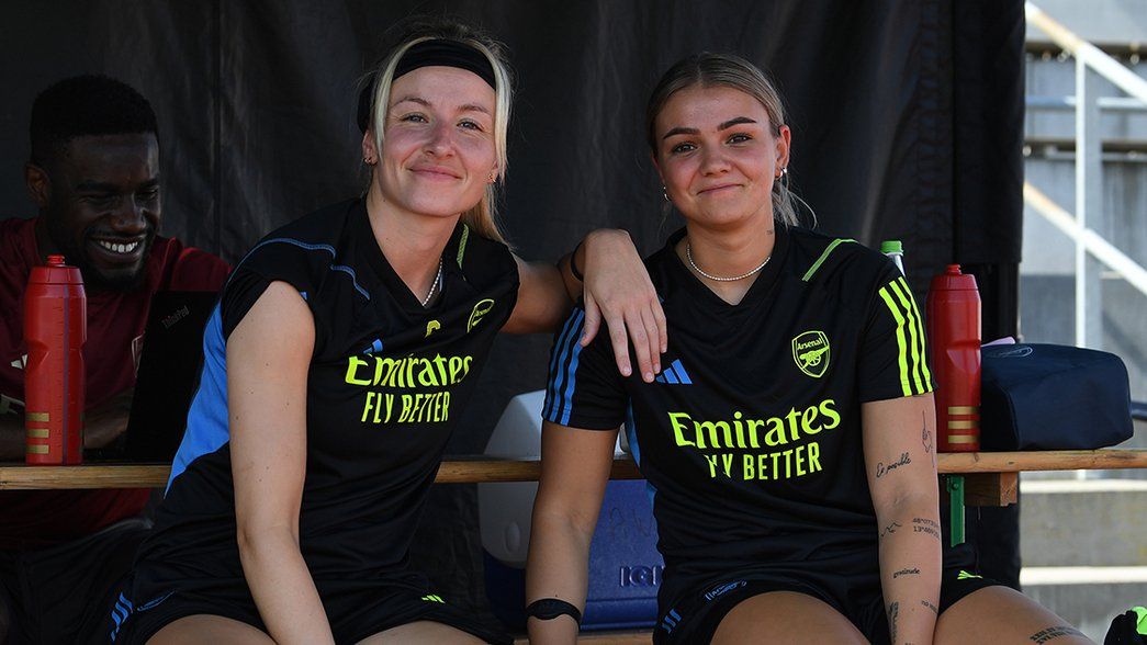 Leah Williamson and Laura Wienroither pose together by the side of the training pitches