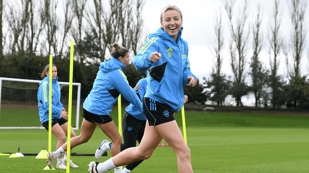 Leah Williamson points at the camera and smiles in training