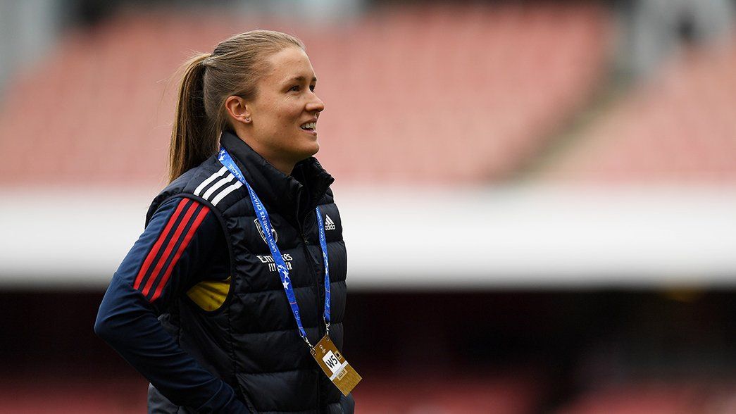 Lydia Bedford smiles whilst walking on the pitch at Emirates Stadium