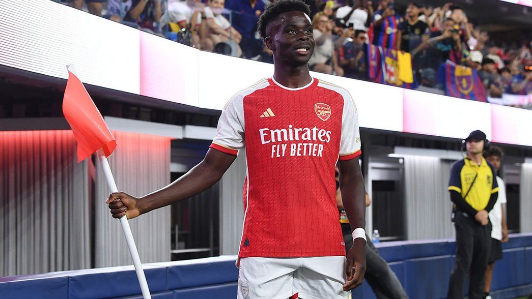 Bukayo Saka celebrates his goal by holding the corner flag
