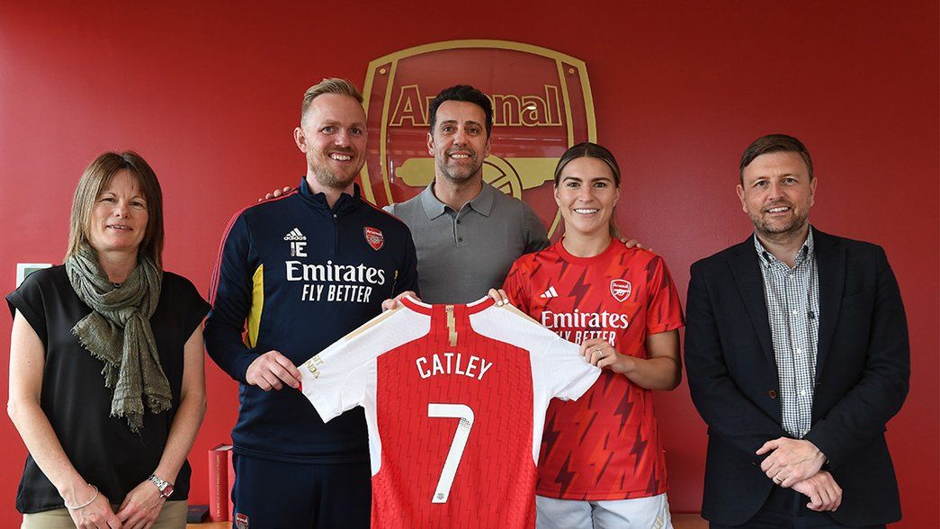 Steph Catley poses with her new shirt in the Arsenal boardroom, alongside Clare Wheatley, Jonas Eidevall, Edu Gaspar and Richard Garlick