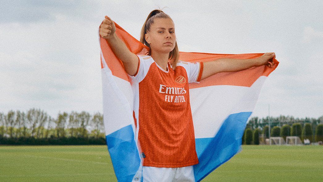 Victoria Pelova poses with a Dutch flag wearing the new Arsenal home shirt