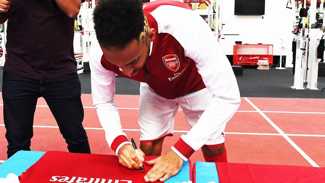 Aubameyang signs a shirt for a competition