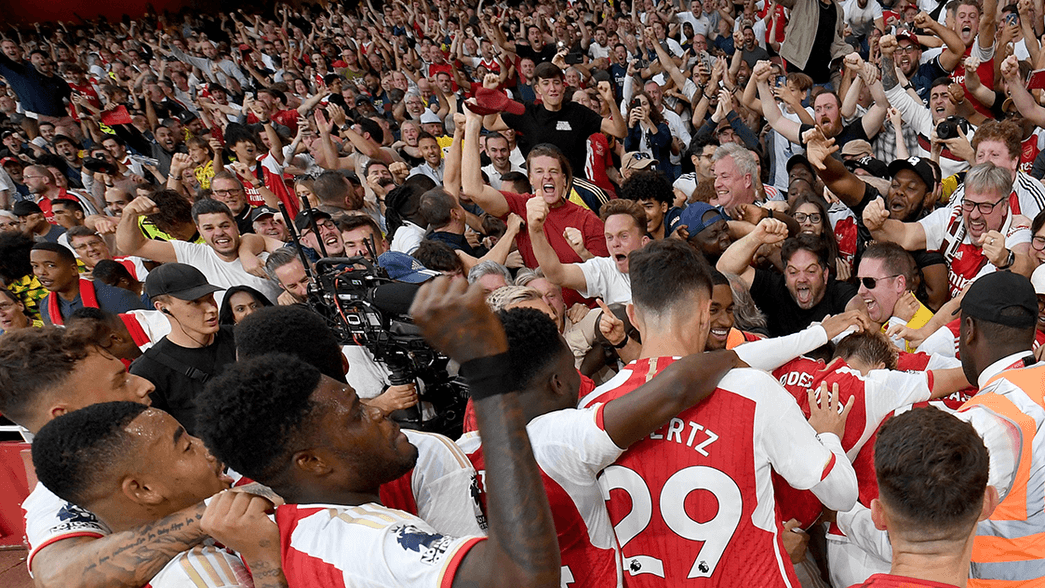 Arsenal celebrate scoring against Manchester City with their supporters