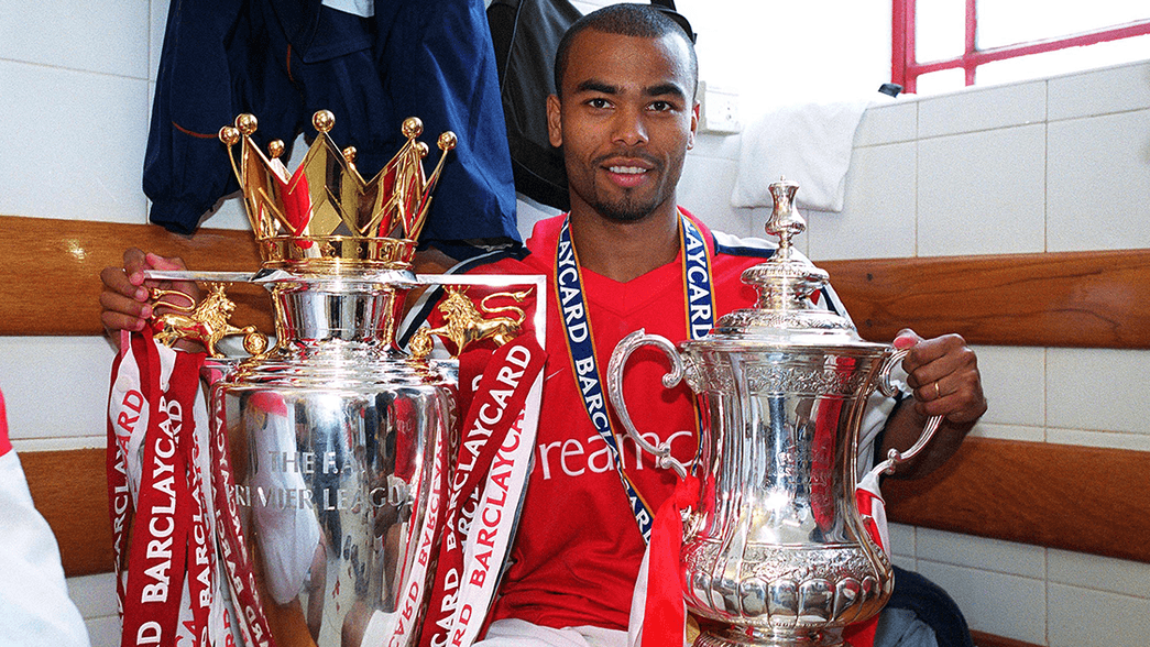 Ashley Cole holds the Premier League trophy and the FA Cup