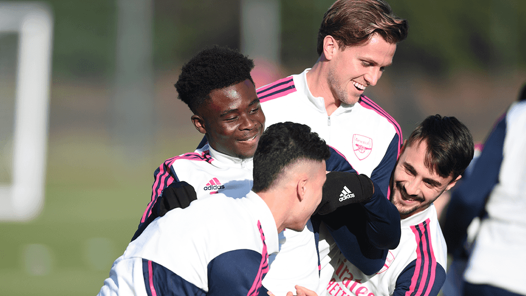 Bukayo Saka is lifted by Rob Holding and Fabio Vieira in training