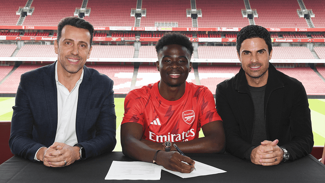 Bukayo Saka signing his new contract alongside Edu and Mikel Arteta
