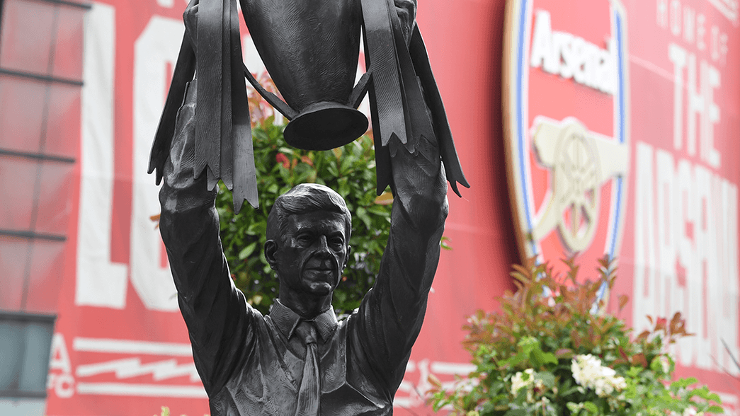 A statue of Arsene Wenger lifting the Premier League trophy