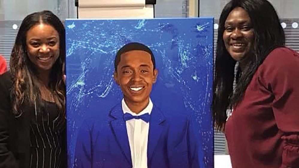 Tanisha and her aunt with a portrait of Stefan that was commissioned by Arsenal