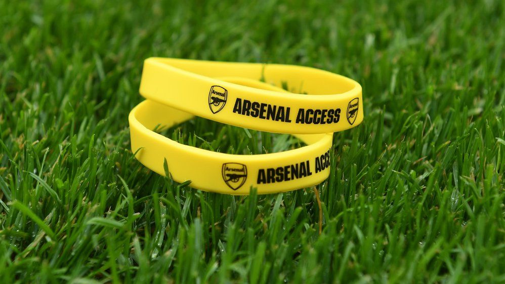 Yellow wristbands with Arsenal Access written on them on pitch