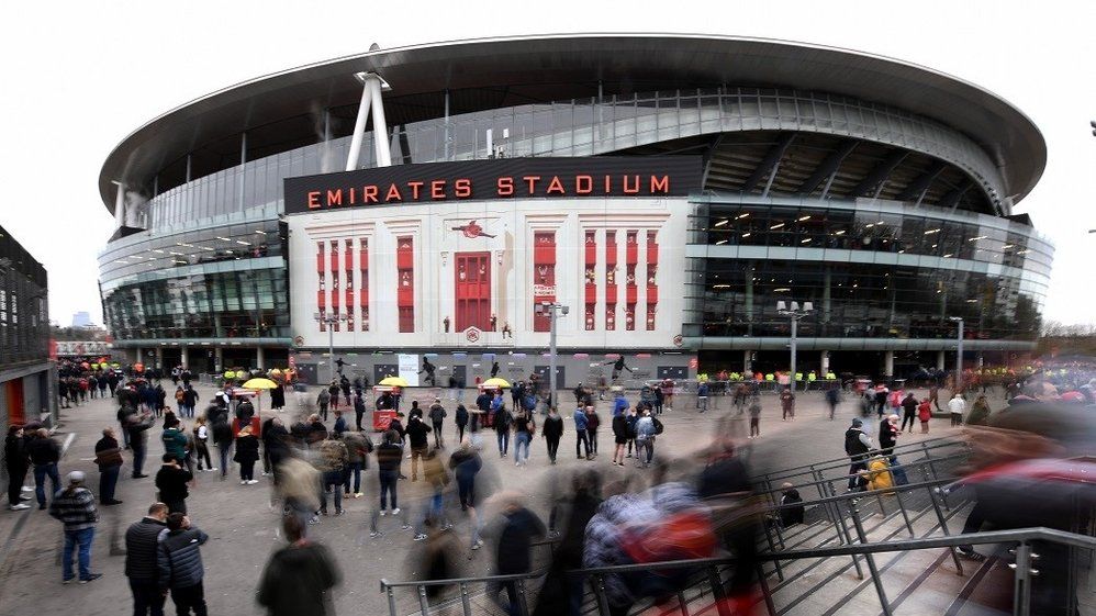 External image of Emirates Stadium on a matchday with supporters passing by.