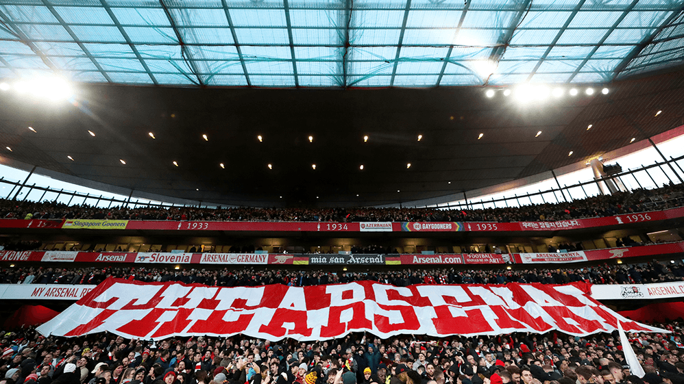 A banner saying The Arsenal being carried over the crowd